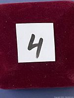 Close-up of red velvet box with number 4 on white paper square.