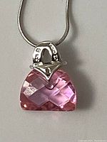 Close-up of the pink faceted stone pendant on sterling silver necklace