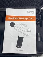 User manual showing illustration of the Wattne W2 handheld massage gun with control panel and handle.