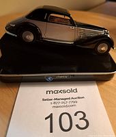 Side profile photo of the Sovido Lancia Astura 1934 model showing detailed design and colors on a display stand.