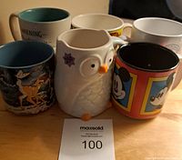 Group photo of six coffee mugs including owl, Mickey Mouse, and Bambi designs from front angle