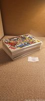Stack of Marvel comic books showing colorful covers of various superheroes.