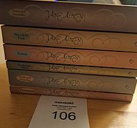 Stack of six Jane Austen paperback books showing titles on spines in beige toned covers with heart designs.
