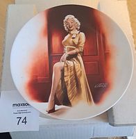 Front view of the collector's plate with Marilyn Monroe image in a golden dress and artist signature.