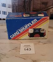 Original boxed packaging for a vintage automatic card shuffler, colorful box with product image and branding.