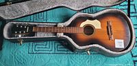 Front view of vintage Framus acoustic guitar in hard case, showing sunburst finish, pickguard, and fretboard.