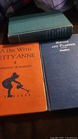 Three hardcover books including orange, blue and greenish covers.