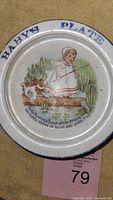 Top view of antique baby's plate showing nursery rhyme illustration and 'BABY'S PLATE' text along rim.