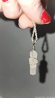 Photo of chain held showing detailed view of wire wrapped crystal pendant and twisted rope chain.