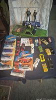 Full lot overview showing green El Camino, action figures, packaged and loose cars.