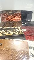 Photo of various Miche outer shells in different patterns like croc texture, leopard print, snake print, patent leather, and others arranged together
