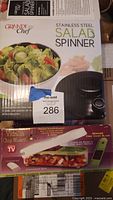 Photo showing boxed Grande Chef Salad Spinner and boxed Vidalia Chop Wizard with bonus dicer blade.