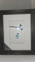 Full view of the framed art showing the twig, sea glass birdhouse, pebble bird, and frame