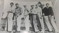 Front view of The Caddy 1953 golf movie black and white photo showing group of eight men on a golf course holding golf clubs.