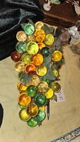 Top view of multi-color glass grapes on wood branch with faux leaves