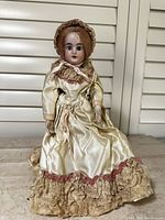 Full front view of the doll showing gown, bonnet, and overall condition