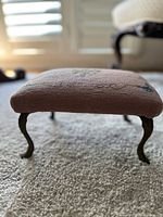 Side view of carved metal legs and pink upholstery fabric