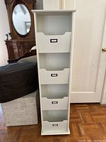 Full view of the white 4-tier Pottery Barn organizer showing all four storage bins with label holders.