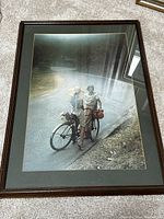 Framed vintage photographic print featuring two women and a bicycle on a roadside.