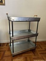 3-tier metal utility bar cart shown full front side, highlighting shelves and wooden handles on top shelf