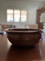 Side view of vintage brown glazed ceramic bowl with visible handmade texture and glossy finish.