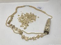 Full view of necklace with elephant-shaped carved beads and scattered loose round beads.