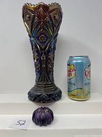 Front view of the tall carnival glass vase next to a soda can for size reference along with the small carnival glass paperweight.