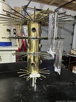 Gold metal chandelier frame showing the structure and hanging mechanisms for the acrylic prisms.