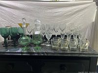 Full lot view showing all crystal and glass items lined up on a black surface against a white draped background.
