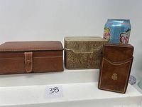 Photo showing all three items: leather box, pottery box, and leather card holder with soda can for size reference