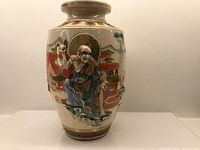 Front view showing raised relief figure holding an object against red band background