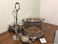 Group shot of all pieces: divided stand, filigree basket, large round dish with glass liner, tea strainer