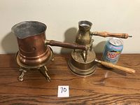 Copper percolator and brass Turkish coffee pot with wooden handles displayed with a Canada Dry soda can for scale.
