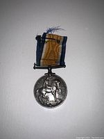 Front view of medal showing St. George on horseback trampling shield and skull and crossbones with 1914 and 1918 dates on reverse side.