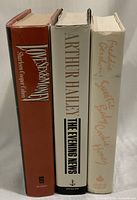 Side view of the three books showing their titles and authors on the spines and dust jackets.