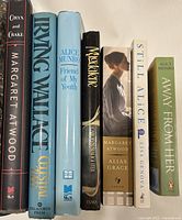 Spine view of 8 books showing titles and authors including Oryx and Crake, The Celestial Bed, Friend of My Youth, Magdalene, Alias Grace, Still Alice, and Away From Her.