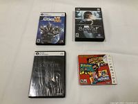 Lot showing four PC game cases with covers visible: Cities XL, Beowulf: The Game, Skyrim, and a sealed Hasbro Board Game Collection.