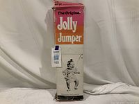 Full front view of the original Jolly Jumper baby exerciser box, showing branding and baby illustration, white background.