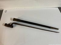 Full view of the bayonet with scabbard showing the entire length, blade, socket, and scabbard.