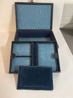 Open view of the interior showing blue silk lining and multiple compartments including velvet trays.