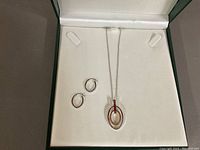 Overall view of necklace and earrings set displayed in green jewelry box