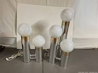 Five white opaline glass globes on chrome pillar bases, two-lamp arrangement