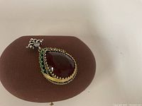 Front view of pendant resting on brown oval stand