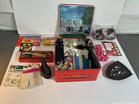 Full lot overview showing Singer tin box, buttons, trims, closures, tracing wheel, and other sewing accessories