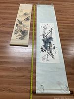 Both scrolls unrolled on floor with measuring tape between them