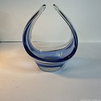 Side view of vintage Chalet art glass basket showing elegant curved pointed design with blue accents.