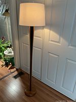 Full front view of lamp with a white cylinder shade installed showing overall shape and height