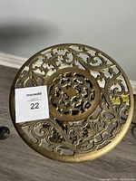 Overhead view showing the detailed open brass filigree with floral and leaf patterns on top of the plant stand.