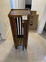 Full view of antique wood plant stand showing height and vertical slat sides