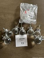 Eight round crystal cabinet knobs with screws laid out, showing condition and shape.